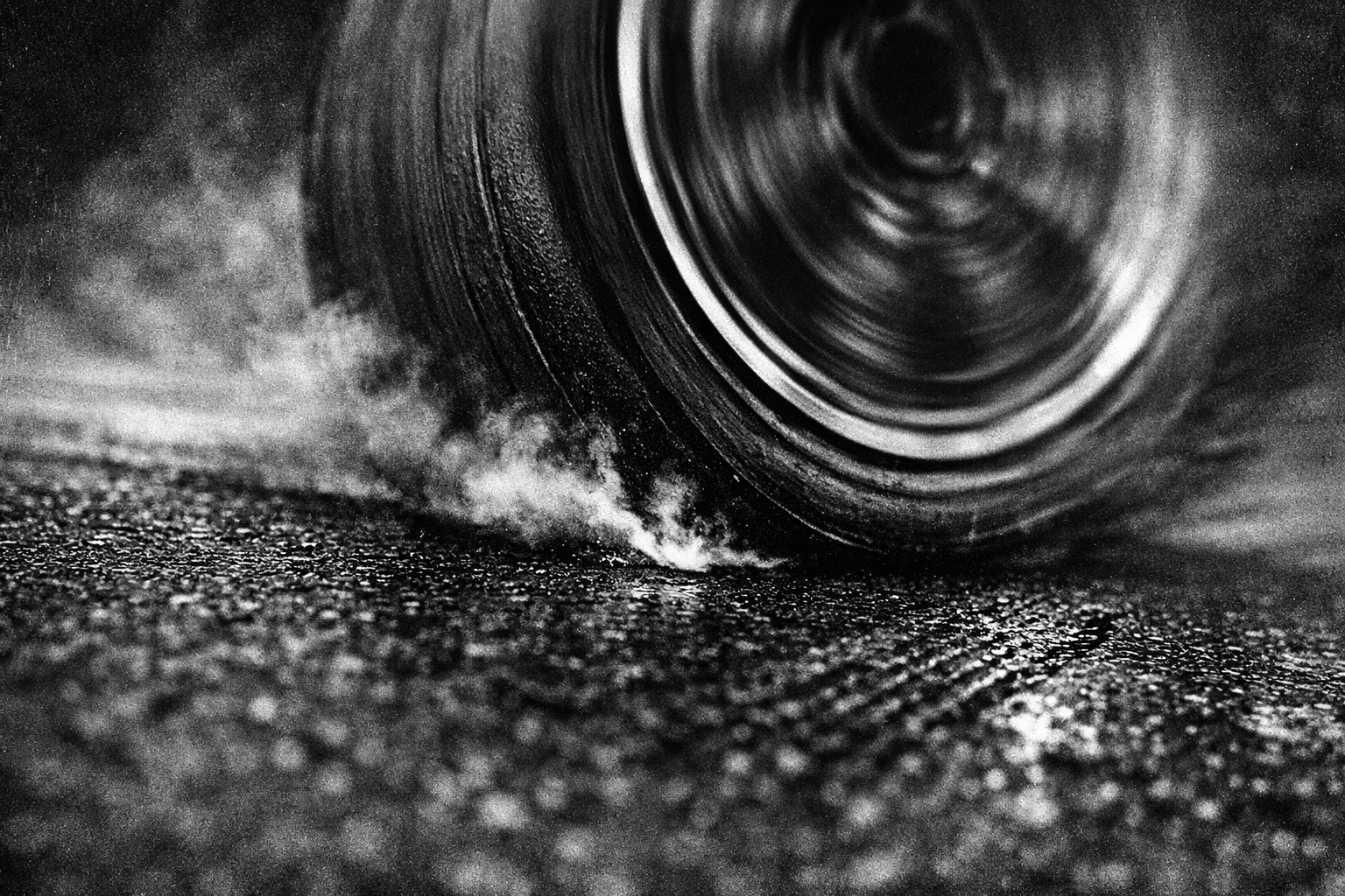 Racing slick tire gripping asphalt at extreme speed. The compound behind FORGED COMPOUND.